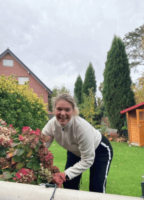 Anna schneidet die Hortensien im Garten zurück